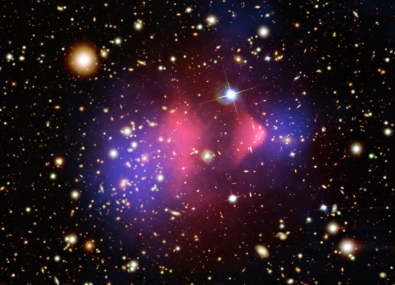 Bullet Cluster (1E 0657−56) composite: pink = hot gas (X-ray), orange/white = galaxies (optical), blue = mass map from gravitational lensing.